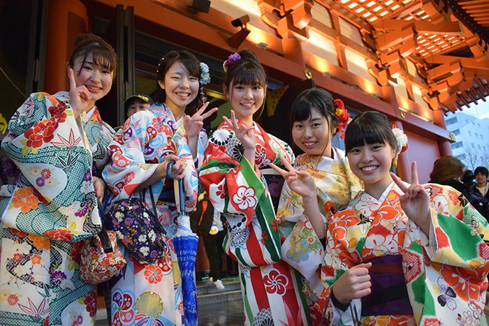 a group of Japanese girls in traditional dress posing for the camera