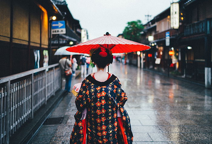 a Japanese Geisha walking down a street