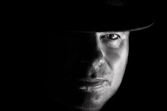 Low key portrait of a men in a hat.