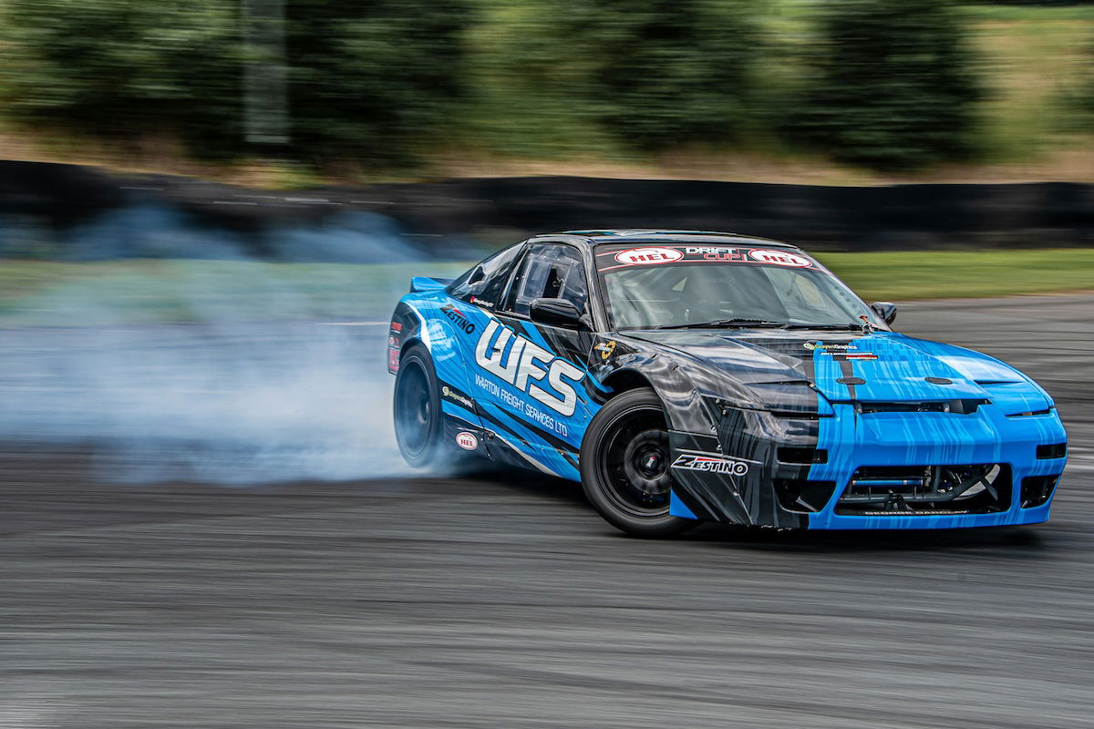 A race car turning on a race track with smoke coming from the tires as an example of motorsports photography