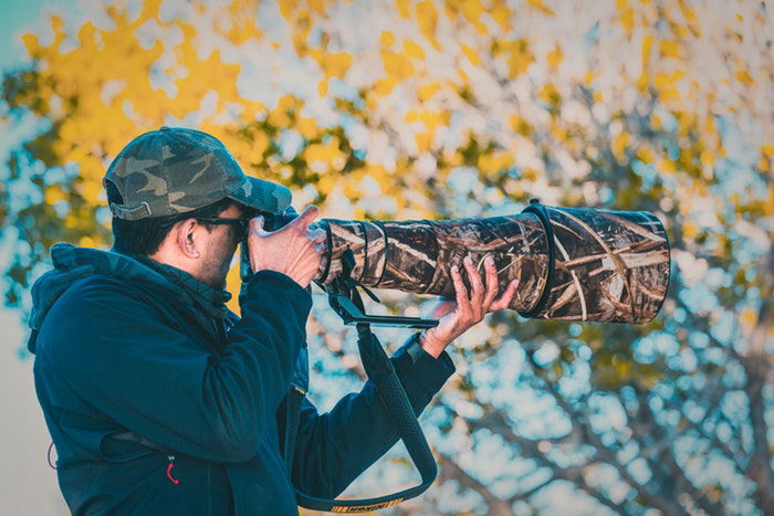 A man holding a telephoto lens