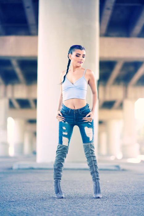 Photo of a girl posing under a bridge