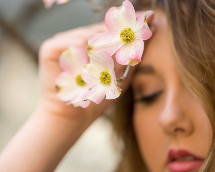 Photo of a girl holding pink flowers in front of her face