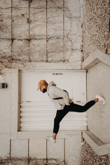 A forced perspective photo of a man taking a step in front of a doorway