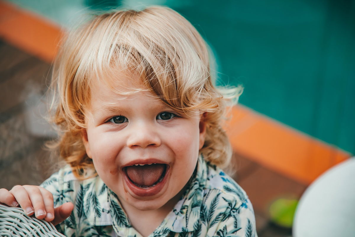 A close-up of a toddler with a big smile for a kids photo pose