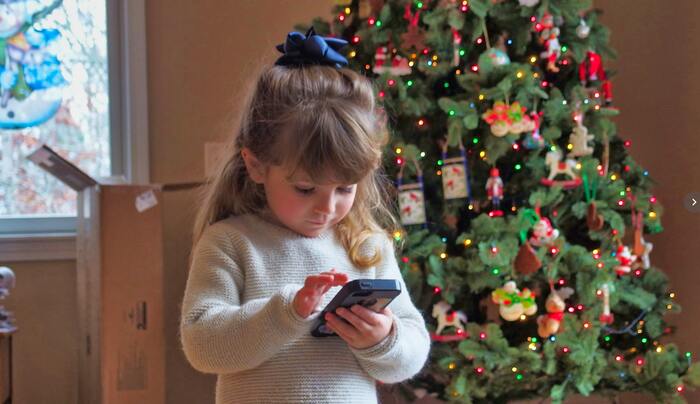 photo of a girl in front of a Christmas tree