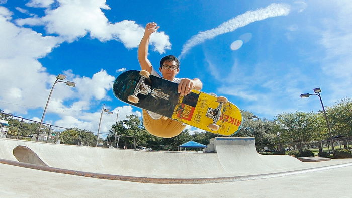 A skateboarder doing a trick midair taken with a wide-angle lens