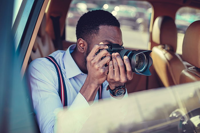 Photographer shooting from car with a DSLR.