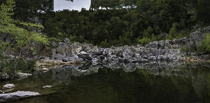 6-image panorama of a rocky lake under trees