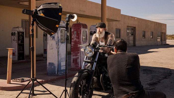 Photo of a guy on a motornike being photographed by a man