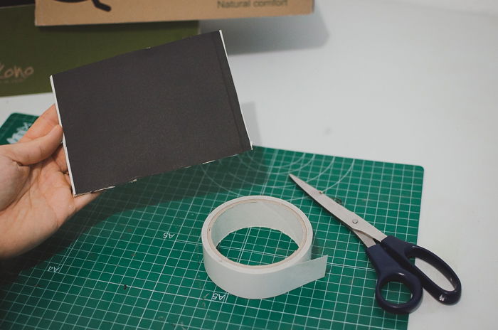 Cutting black paper and a shoe-box to make a DIY projector