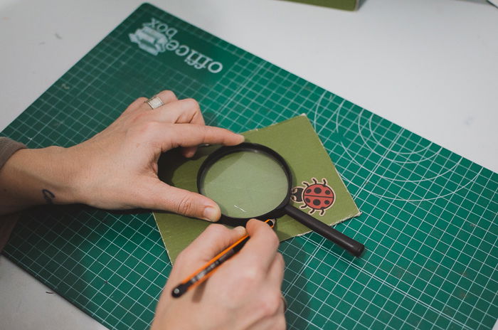 A person cutting cardboard to make a DIY phone projector