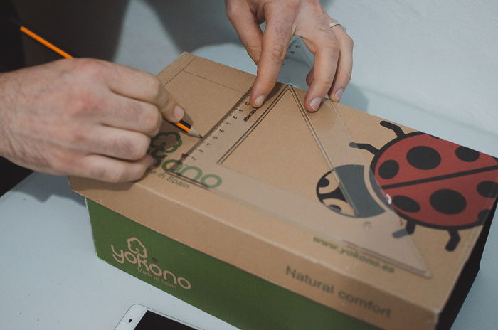 A person measuring a DIY smartphone photo projector