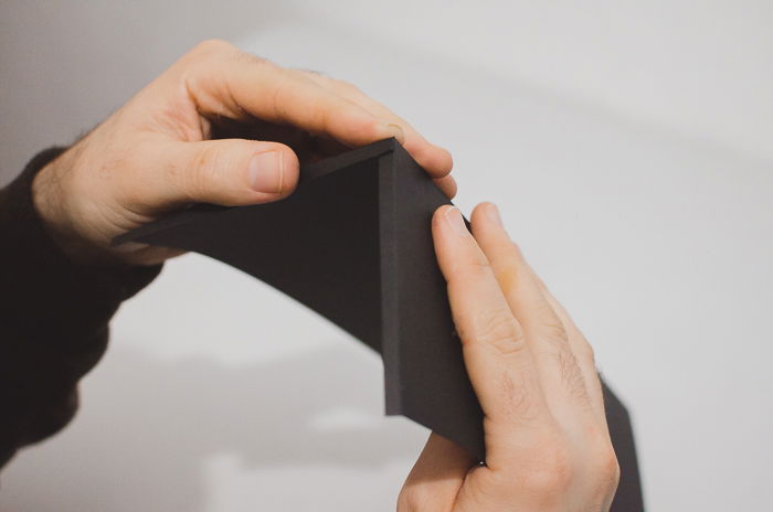 A person folding black paper to make a DIY phone lens projector