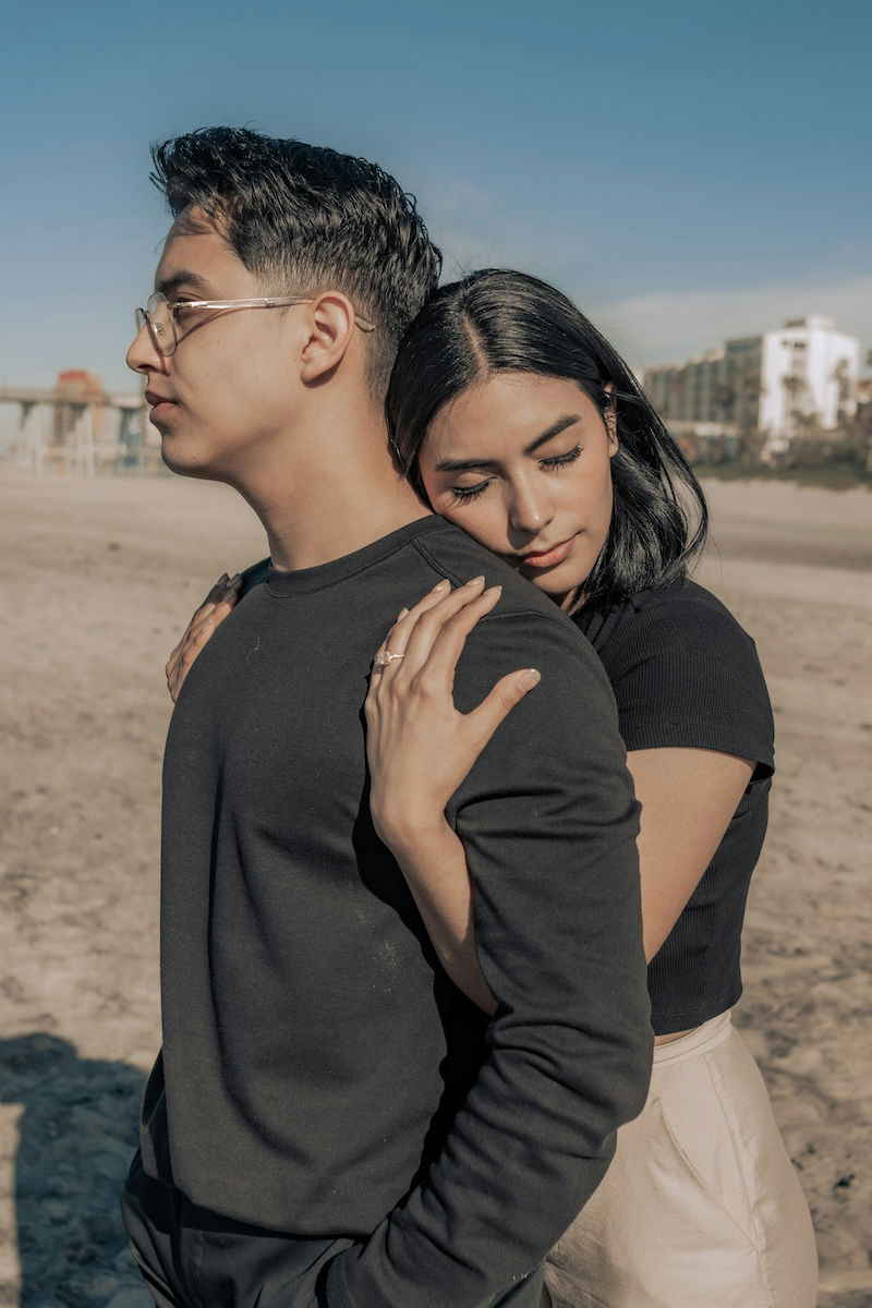 A woman hugging a man from behind for couple poses