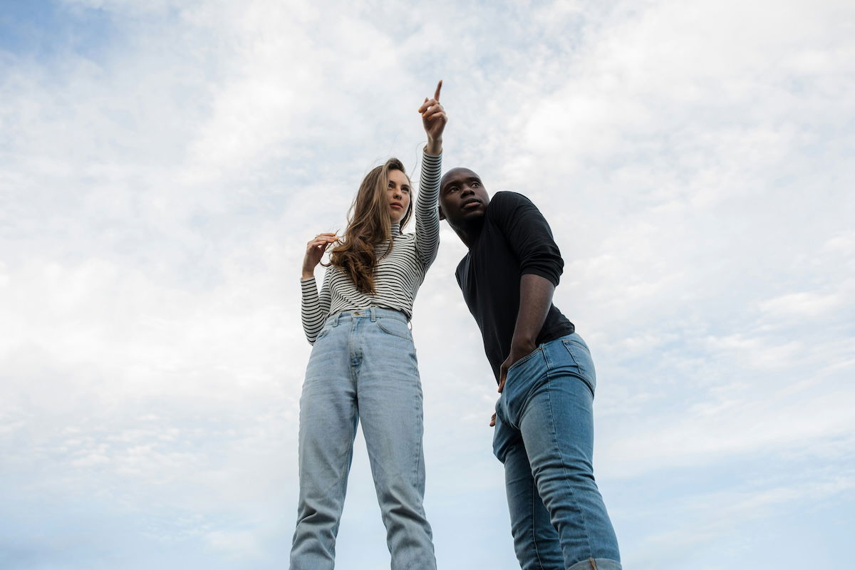 Woman pointing with man beside her for couple poses