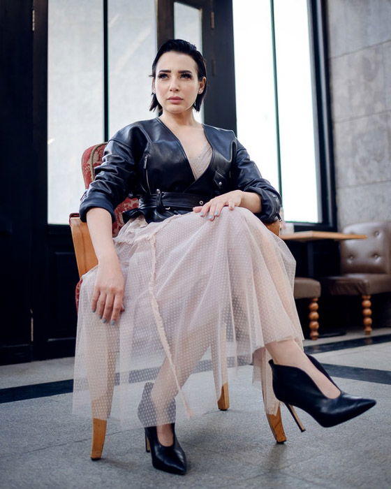 A glamorous fashion model sitting indoors