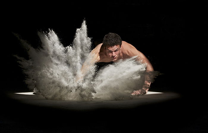 A man exercising surrounded by flour