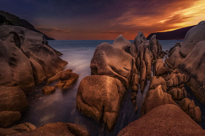 Photo of cliffs on a beach at sunset