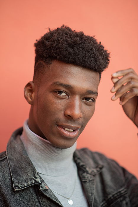 Closeup portrait of a confident man behind a colorful background.