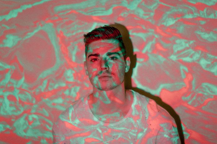 A portrait of a man with a projected photo of abstract colors over him