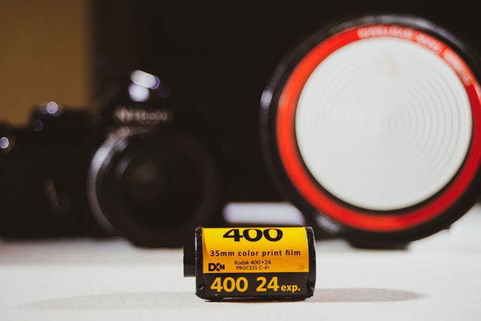 A close up of a roll of film with camera in the background