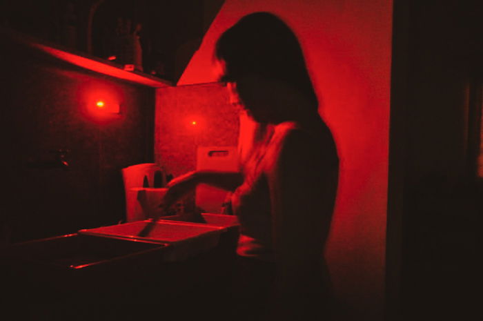 A girl developing film in a DIY darkroom