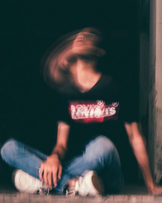 Creative long exposure portrait of a man sitting on the ground