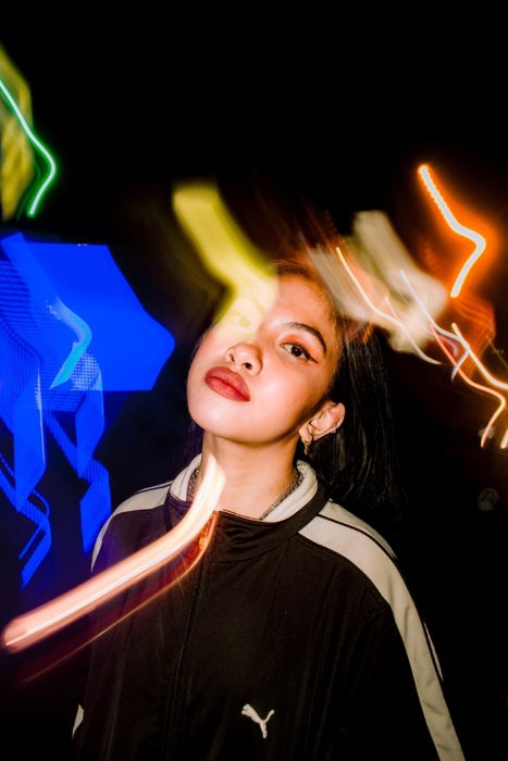 Creative portrait of a young girl surrounded by streaks of light