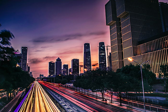 Night cityscape with light trails of moving traffic