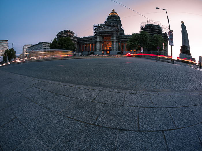 Light trails of traffic outside a large building at evening