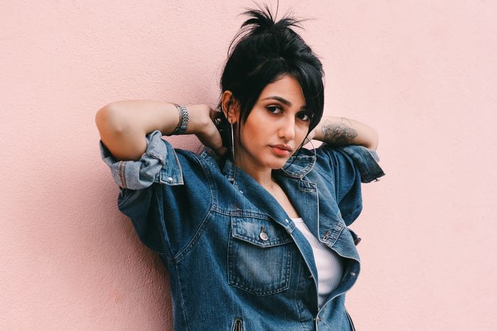 Portrait photo of a woman in front of a pink wall