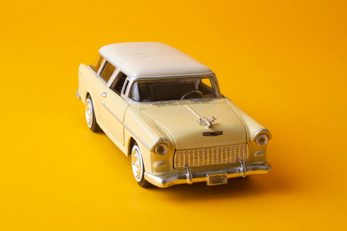 A sharp image of a toy car on a yellow background