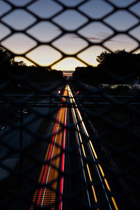 Photo from a bridge showing the light trails of the passing cars below