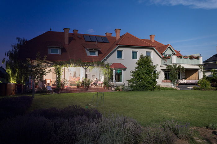 Photo of a house with the daytime sky on the right merging into the night sky on the left