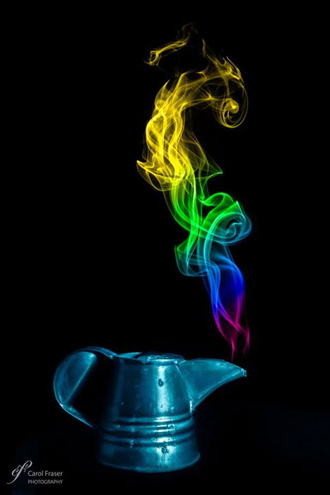 A tea pot with colorful smoke coming out of it