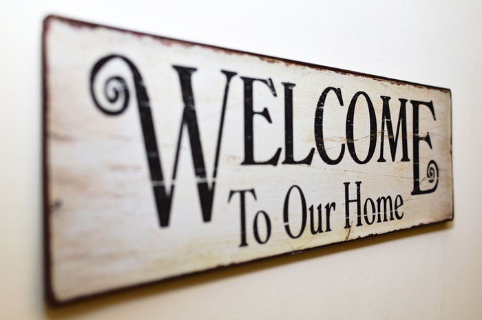 A wooden sign reading 'Welcome to our Home'