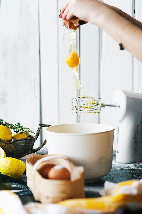 Cracking an egg into a mixing bowl