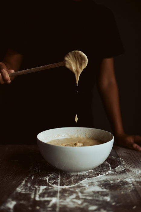 A person stirring batter in a white bowl