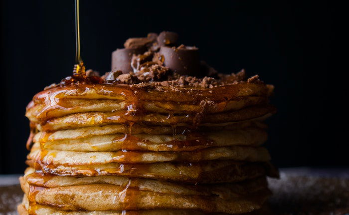 Delicious iphone food photography of syrup being poured on pancakes