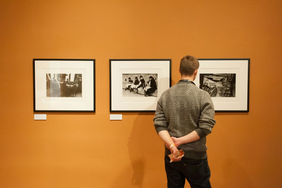 A person looking at framed photographs in a photo gallery