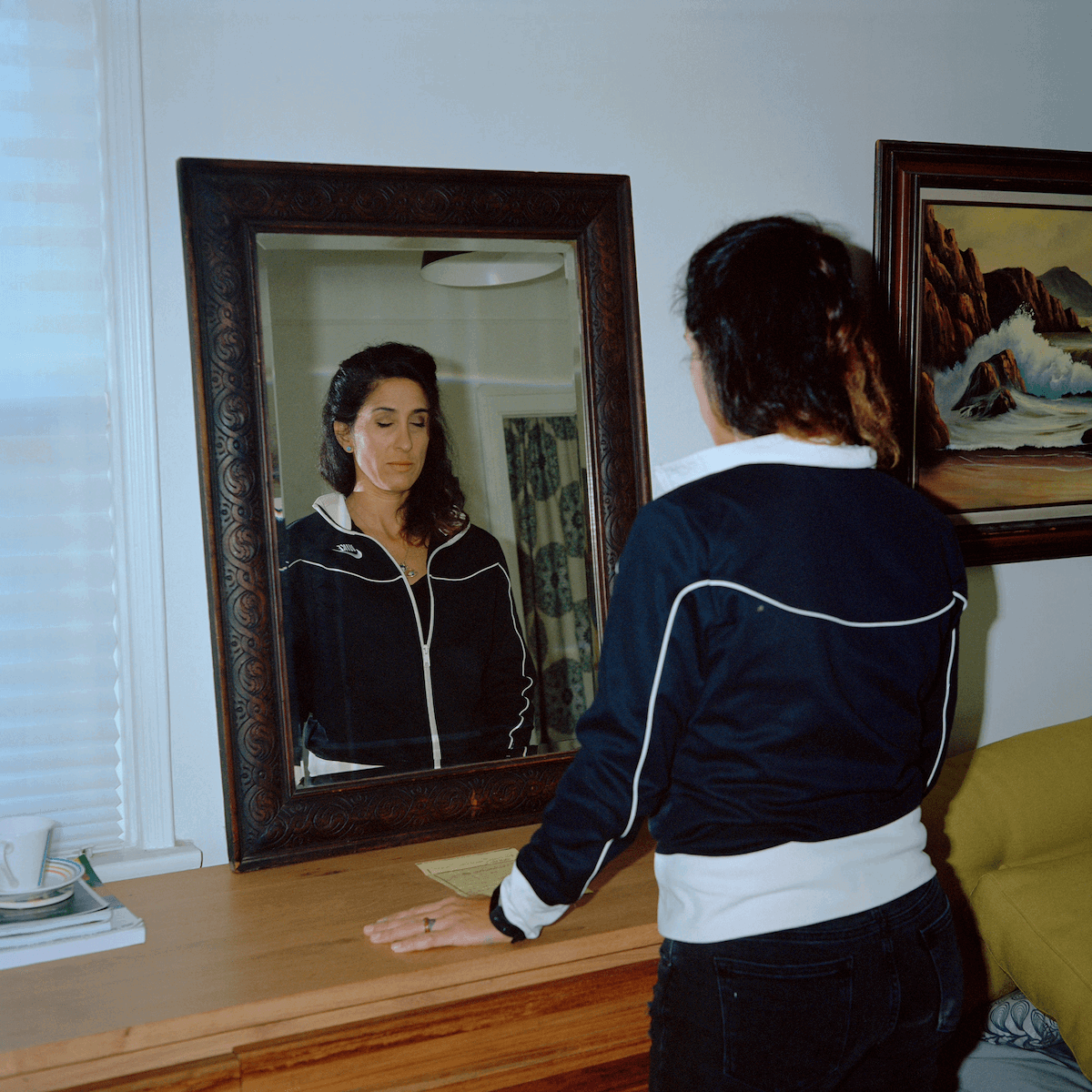 Twin Flames #49. Alyson & Courtney Aliano by Justin Aversno of a woman with her eyes closed in front of a mirror as one of the most expensive photographys