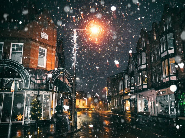 A snowy city street scene at night