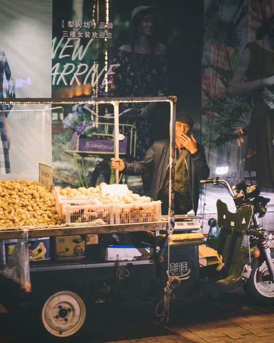 A street vendor smoking at his stall at night