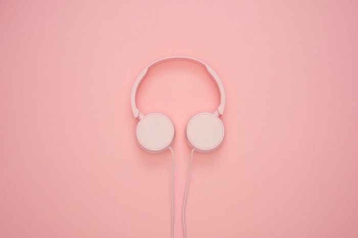 Pink headphones against a pink wall