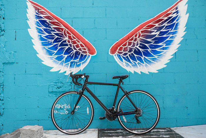 A bike leaning against a graffitied wall