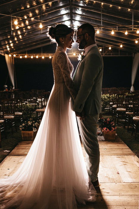 A newlywed couple embracing in an empty venue