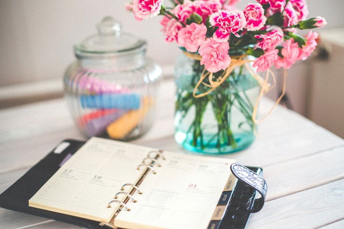 Flowers and chalks beside an open diary notebook