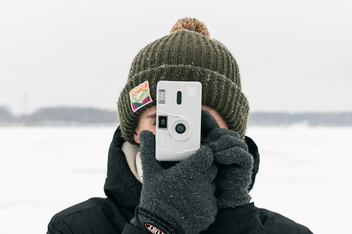 Person holding up an 35mm film camera to take a picture for a 30-day photo challenge