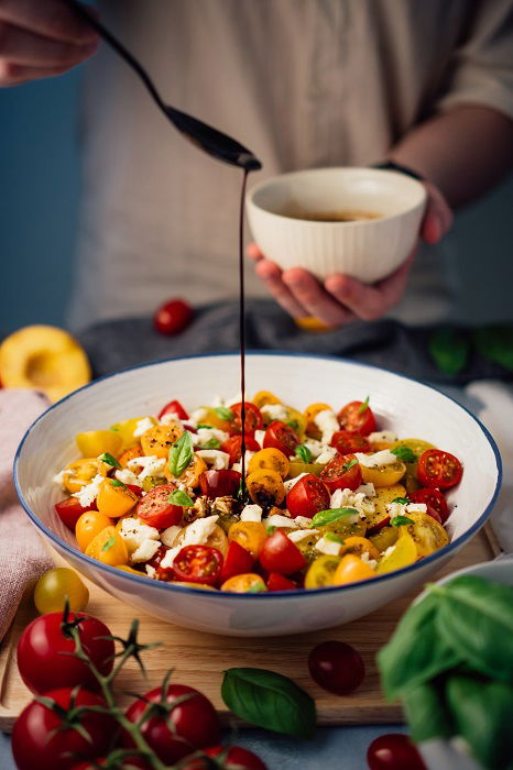 Food styling tips: drizzling a spoonful of balsamic glaze onto a bowl of salad